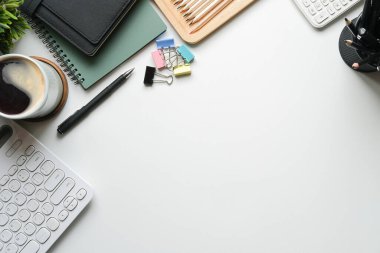 Kahve fincanının, not defterinin ve hesap makinesinin üzerinde beyaz arkaplan ve kopyalama alanı.