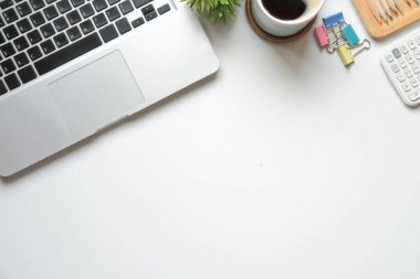Laptop bilgisayar, hesap makinesi ve kahve fincanı beyaz masada. Düz konum, Üst görünüm, Boşluğu kopyala.
