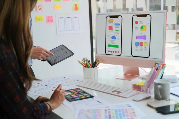 Ux geliştiricisi ve ui tasarımcısı, yaratıcı ofiste mobil uygulama kablo tasarımı üzerinde çalışırken modern aygıtlar kullanıyor..