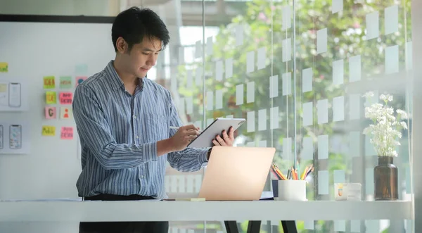 Young male website developer working in a software develop company office.