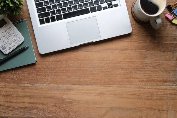 Bilgisayar dizüstü bilgisayar, kahve fincanı, defter ve hesap makinesi ahşap masada. Düz konum, Üst görünüm, Boşluğu kopyala.