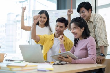 Heyecanlı genç iş adamları iş zaferini ya da ofiste başarıyı kutluyorlar. Takım çalışması, işbirliği konsepti.