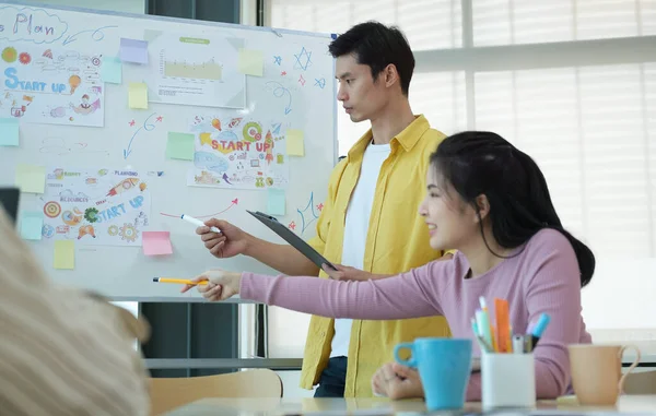 Asyalı iş adamlarından oluşan bir grup modern bir ofiste toplanıyor..