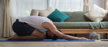 Evde antrenmandan önce yakışıklı bir sporcu ısınıyor. Spor, spor ve sağlıklı yaşam tarzı konsepti.