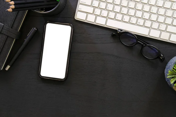 Flat lay mobile phone, computer, coffee cup and stationery on wooden table.	