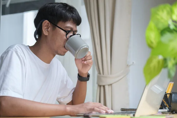 Young Asian Man Drinking Coffee Surfing Internet Computer Laptop Home — 스톡 사진