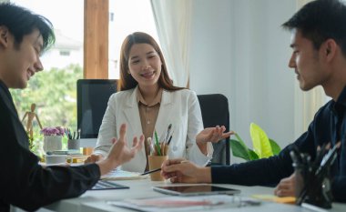 Group of young creative coworkers brainstorming and discussing new startup project together in office.	