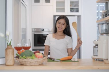 Çekici genç bir kadın mutfak tezgahında duruyor ve sağlıklı salata yapıyor. Diyet, sağlıklı yaşam tarzı konsepti.