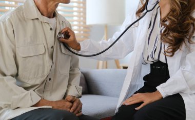 Stetoskop tutan kesik kadın doktor yaşlı hastanın kalbini dinle. Tıbbi sağlık hizmeti kavramı.