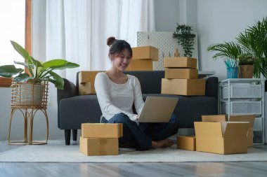 Küçük işletme girişimcisi dizüstü bilgisayar kullanıyor, müşterinin siparişini kontrol ediyor. Başlangıçta küçük işletme, çevrimiçi satış, E-ticaret kavramı.