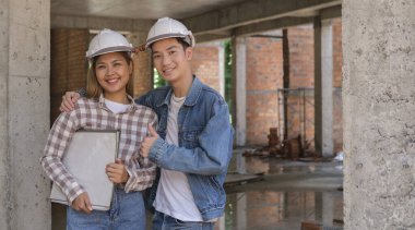 İnşaat alanında duran ve kameraya gülümseyen uzmanlardan oluşan bir ekip..