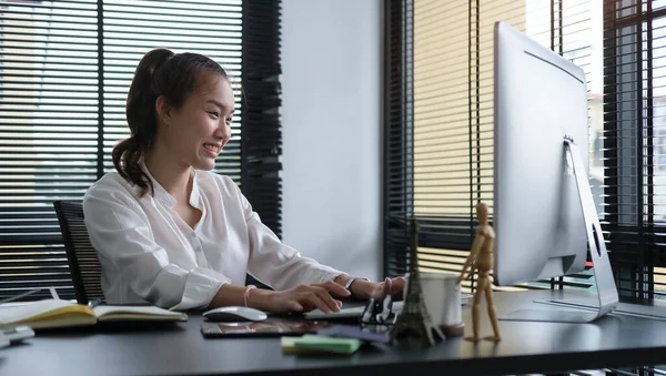 Gülümseyen Kadını Modern Ofiste Oturuyor Bilgisayarla Çalışıyor — Stok fotoğraf