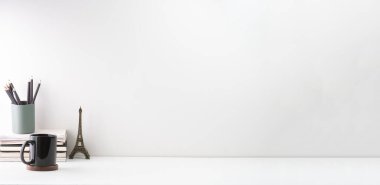 Kitapların, kahve fincanının ve kalem tutacağının olduğu küçük bir iş yeri. Metnin için boşluk kopyala.