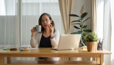 Rahatlamış orta yaşlı, bir fincan sade kahveyle ve hafta sonunun keyfini çıkarıyor..