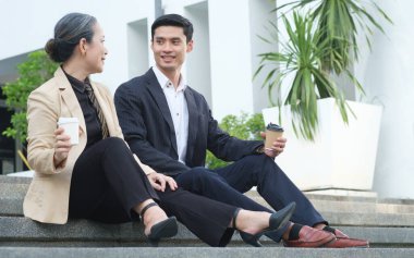 Ofis binasının merdivenlerinde oturmuş birbirleriyle konuşan iki iş adamını vurmak..