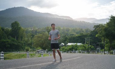 Yakışıklı genç adam sabah şehir parkında koştuktan sonra dinleniyor. Fitness, sağlıklı yaşam tarzı, spor, stres ve aktivite konsepti.