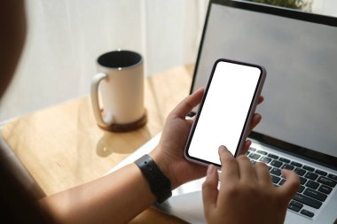 Close up view woman holding smart phone with empty screen for your text message or information content.	