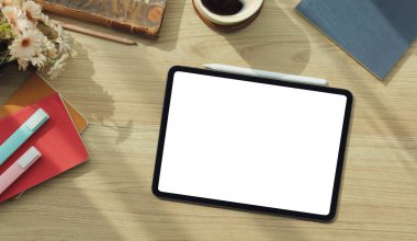 Top view modern workspace with digital tablet, stylus pen and coffee cup on wood table.	