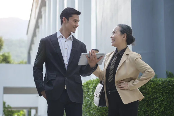 Shot of two successful business people talking to each other while  walking outdoors at the city streets