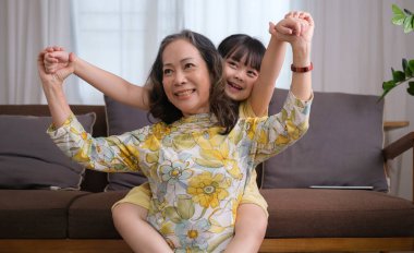 Mutlu büyükanne, küçük torunuyla oturma odasında oynarken çok eğleniyor..