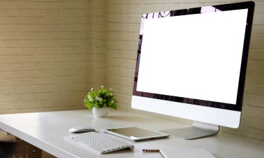 Modern workplace with computer pc, books, and coffee cup on white table.	
