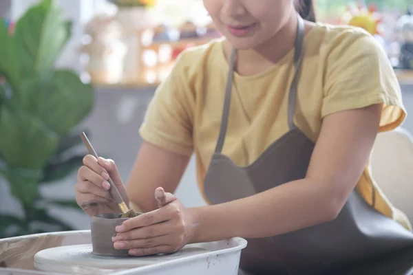 Woman potter making ceramics on pottery wheel. Creative activities, pottery, workshop, ceramics art concept.