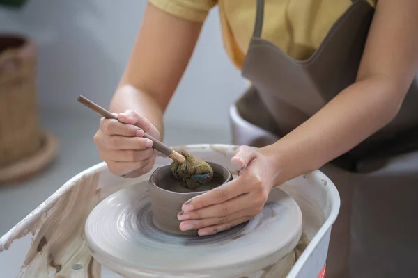 Creative handicraft woman working on pottery wheel in handmade ceramics workshop. Pottery, ceramics art concept.