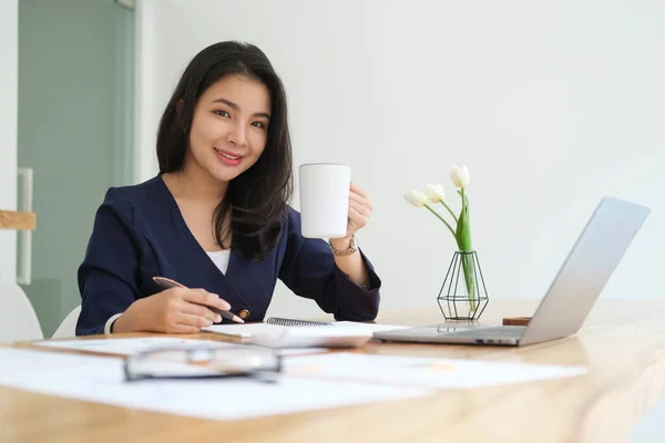 魅力的な若い女性起業家保持カップのコーヒーと笑顔でカメラ — ストック写真