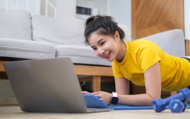 Spor yapan genç bir kadın sabah antrenmanı sırasında bilgisayar kullanıyor. Spor, spor ve sağlıklı yaşam tarzı konsepti.