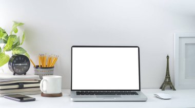Computer laptop with empty screen, coffee cup, and potted plant on table. Home office.