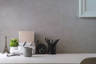 Resim çerçeveli, kahve fincanı, ev bitkisi ve kırtasiyeli ofis masası. Reklam metniniz için alanı kopyalayın.