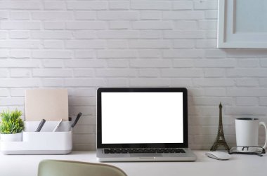 Mock up laptop computer, picture frame, coffee cup, books and pencil holder on white office desk.	