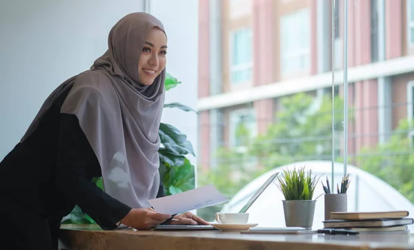 stock image Successful young muslim female corporate CEO planning investment strategy for startup project, working with financial document at office.