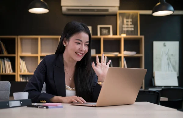 Smiling young woman looking at laptop screen, make conference business call or distance job interview.