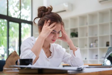Stresli kadın çalışanlar iş yerinde yorgun, baş ağrısı, iş yerinde stres ya da migren şikayeti var.. 