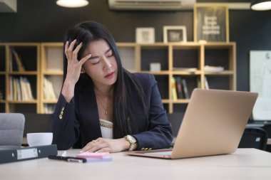 Yorgun Asyalı kadın girişimci baş ağrısı çekiyor tapınaklara dokunuyor, iş stresi ya da migren..