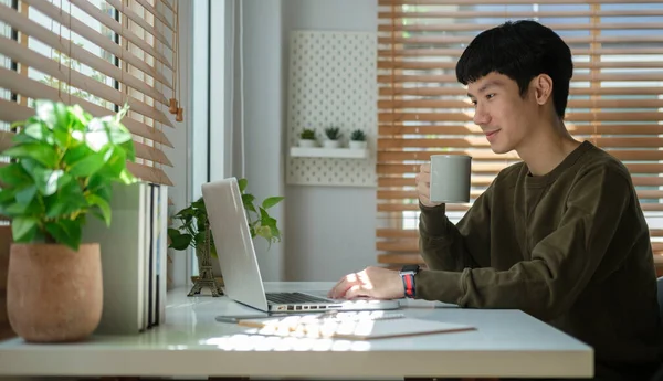Smiling Asian Male Freelancer Drinking Coffee Checking Email Laptop Computer — Stock Photo, Image