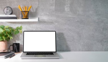 Laptop computer, house plant and supplies on white table. Blank screen and copy space for your advertise text.