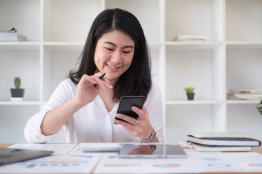 Sosyal medyada iletişim kurmak için akıllı telefon kullanan mutlu genç bir kadın..