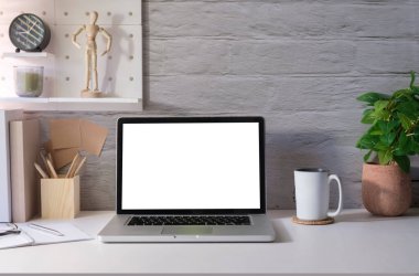 Bilgisayarı, malzemeleri ve çiçek saksısı olan parlak modern ofis. Reklam metniniz için boş ekran.