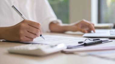 Professional female accountant working with financial statistics graphs at office desk.	