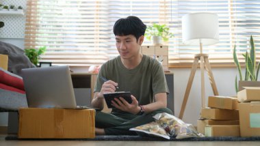 Young startup online seller checking customer orders,  accepting an online order on laptop.