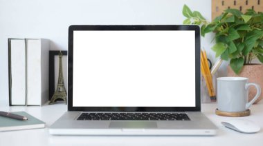 Mock up laptop computer, coffee cup houseplant and stationery on white table. Empty screen for your advertise text.