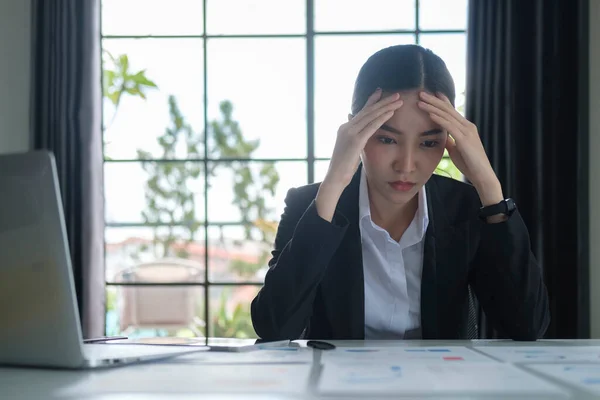 Stressed female employee feeling tired at work, suffering from headache, stress at work or migraine.
