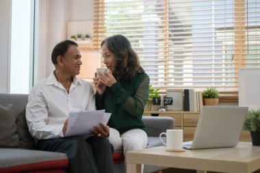 Happy senior couple using laptop together for shopping online or surfing internet. Retired life concept.