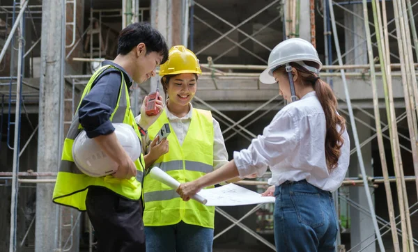 Engineer team discussing the structure of the building with architects at construction site.