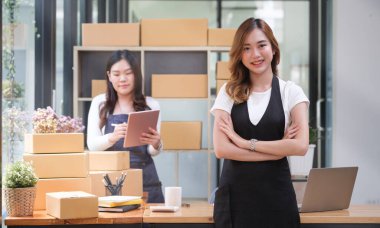Confident startup small business entrepreneurs standing with arms crossed and smiling to camera. Online selling and e-commerce business concept.
