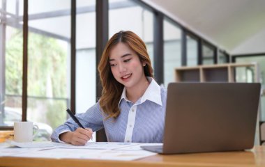 Modern iş yerinde bilgisayar tableti kullanan güzel bir ofis çalışanı..