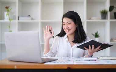 Cheerful working woman waving hand, chatting online, making video call on laptop computer.	