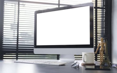 Boş ekranlı bilgisayar bilgisayarı, kahve fincanı ve malzemeler ahşap ofis masasında..